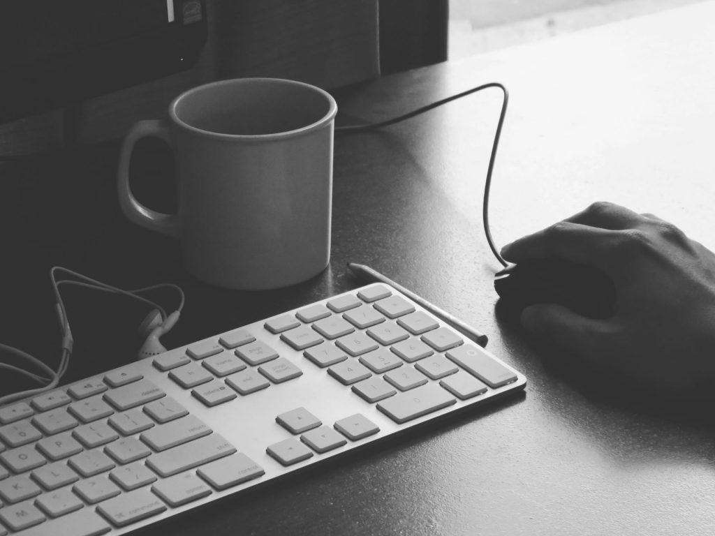 B+W writing at computer. Photo by Rayi Christian Wicaksono on Unsplash